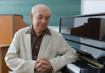 Octavian Nemescu sitting next to a piano.